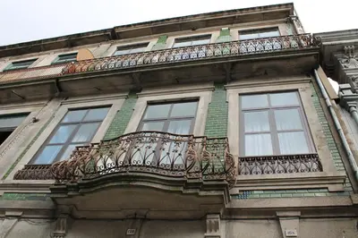 a balcony on the side of a building with windows at Guest House Henrique VIII in Porto