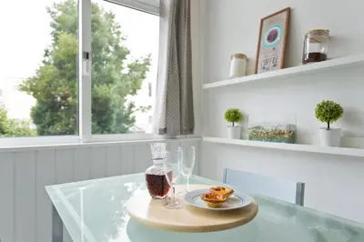 a glass table with a plate of food and glasses at L&M Apartment in Porto