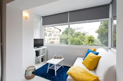 a bedroom with a large window and a bed and a table at L&M Apartment in Porto