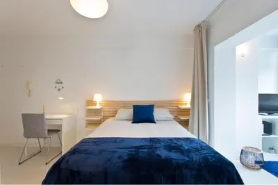 a bedroom with a large bed and a desk at L&M Apartment in Porto