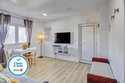 a living room with a bed and a table and a tv at Casa de Gaia in Vila Nova de Gaia