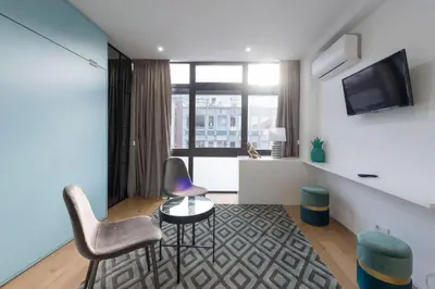 a living room with two chairs and a table and a tv at LovelyStay - Wohaza Apartment with free private parking in Porto