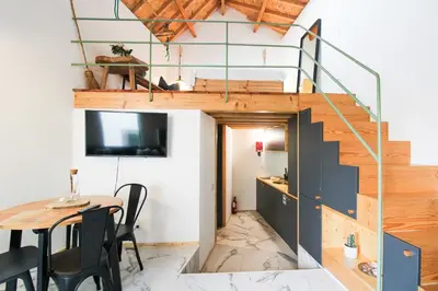 a tiny house with a staircase and a table at Macário Cosy Loft in Porto