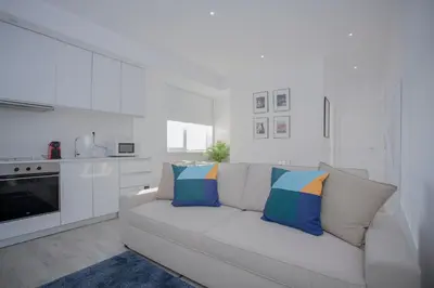 a white living room with a white couch with pillows at Liiiving in Porto | Center Spot Apartment in Porto