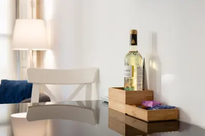 a bottle of wine sitting on a table next to a chair at CASA JOY Boavista apartment in Porto