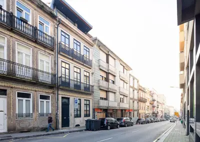 a person walking down a city street with buildings at CASA JOY Boavista apartment in Porto