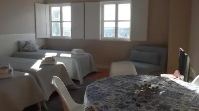 a living room with tables and chairs and windows at The Porto Way in Porto