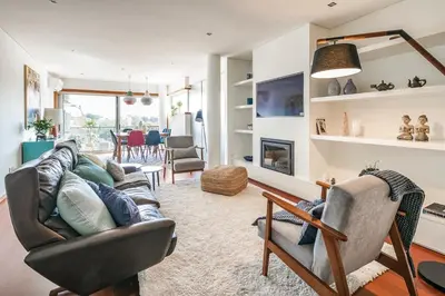 a living room with a couch and chairs and a fireplace at Charming Bonfim Penthouse in Porto