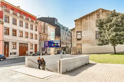 two people walking on a city street with buildings at Charming Bonfim Penthouse in Porto