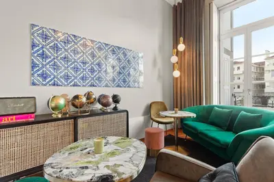 a living room with a green couch and a table at The White Box Boutique House in Porto