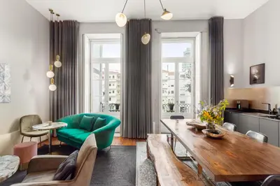 a living room with a table and a green couch at The White Box Boutique House in Porto