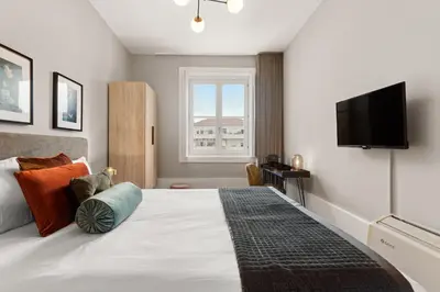 a bedroom with a large bed with a flat screen tv at The White Box Boutique House in Porto