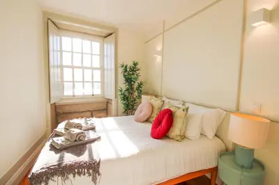 a bedroom with a white bed with pillows and a window at Douro Divine in Porto