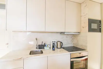 a kitchen with white cabinets and a sink at Douro Divine in Porto