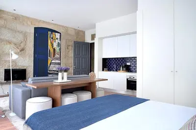 a bedroom with a bed and a table and a kitchen at Mayor's Apartments in Porto