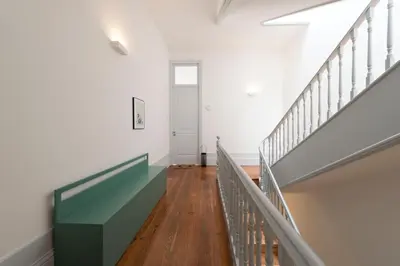 a hallway with a staircase and a dresser with a plant on it at Tripas-Coração, Sá da Bandeira in Porto