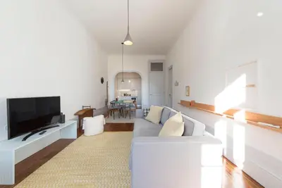 a living room with a couch and a tv at Tripas-Coração, Sá da Bandeira in Porto