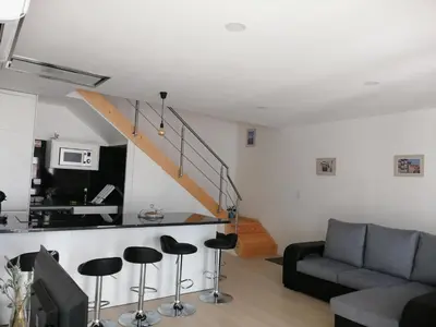 a living room with a couch and stools at Casa Ventuzelo in Porto