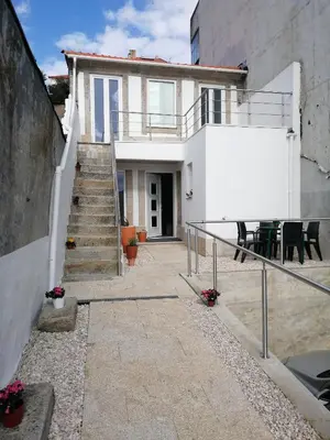 a white house with stairs and a table and chairs at Casa Ventuzelo in Porto
