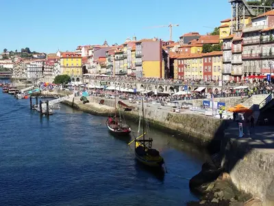 two boats are docked in a river in a city at Historic Oporto Apartment at oporto UNESCO area, in front of Porto Wine caves in Porto