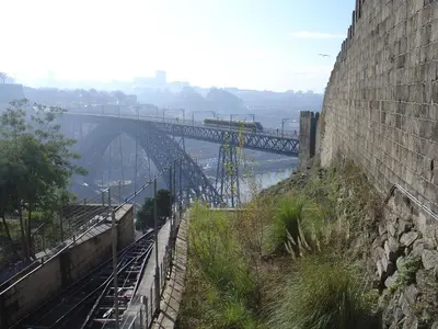 a train is crossing a bridge over a river at Historic Oporto Apartment at oporto UNESCO area, in front of Porto Wine caves in Porto