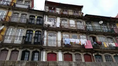 an old building with clothes drying on a balcony at Historic Oporto Apartment at oporto UNESCO area, in front of Porto Wine caves in Porto