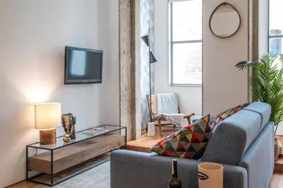 a living room with a couch and a tv at Apartamentos Villa Bolhao in Porto
