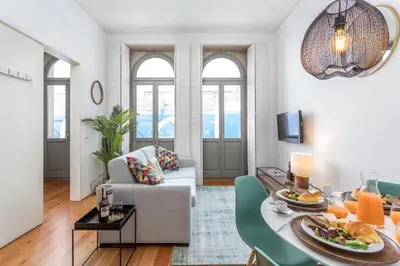 a living room with a table and a couch at Apartamentos Villa Bolhao in Porto