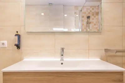 a bathroom with a white sink and a shower at Marquês Deluxe Apartment in Porto