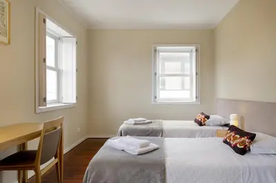 two beds in a room with two windows at Casas Da Formiga - Riverview Terrace and Pool in Porto