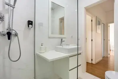 a white bathroom with a sink and a shower at Luxury Anibal Cunha Apartments in Porto