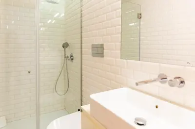 a white bathroom with a shower and a sink at APOSENTUS - Charming Center Apartment with Balcony in Porto