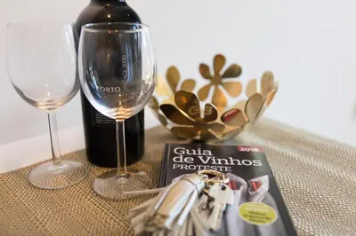 a bottle of wine and a glass and a magazine at Casa D'ouro in Porto