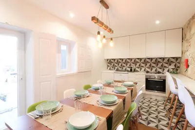 a kitchen with a wooden table and green chairs at PORTO CONCEPT HOME - Paranhos in Porto