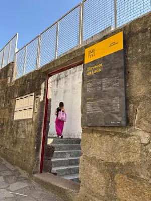 a woman taking a picture of a person through a doorway at By this River in Porto