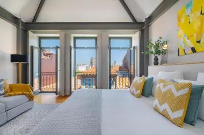 a bedroom with a large white bed and large windows at Canto De Luz - Luxury Maison in Porto