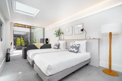 a bedroom with two beds and a living room at Canto De Luz - Luxury Maison in Porto