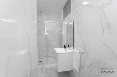 a white bathroom with a shower and a sink at Downtown 3 Bedroom with Balcony - Quiet Street - Family Friendly - Groups in Porto