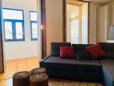 a living room with a blue couch and two stools at Oporto Chic&Cozy - Santo Ildefonso in Porto