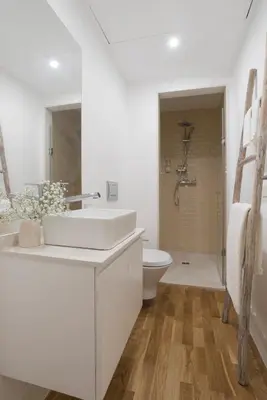 a bedroom with a white bed with two lamps at Casa Oliveira in Porto