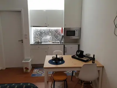 a small kitchen with a wooden table and chairs at Porto Central City Heart I & II in Porto