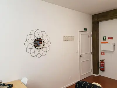 a room with a white wall with a clock on the wall at Porto Central City Heart I & II in Porto