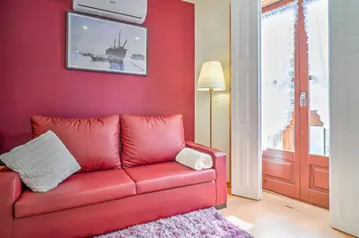 a red couch in a living room with a red wall at Port Wine Flats in Vila Nova de Gaia