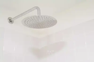 a shower with a light on a white wall at VIVA Historic Centre Downtown in Porto