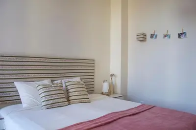 a bedroom with a bed with white sheets and pillows at Sweet Swell in Porto