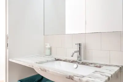 a white bathroom with a sink and a mirror at VIVA Breiner Flats in Porto
