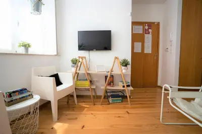 a living room with a desk and a tv on the wall at Downtown Porto Relaxed Apartment with Private Yard in Porto