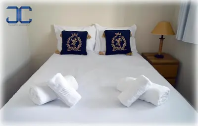 a white bed with four white towels on it at Pardal Apartment by JC in Porto