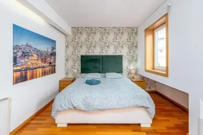 a bedroom with a bed with a green headboard at Cedofeita Exclusive with parking included in Porto