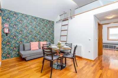 a living room with a table and chairs and a couch at Cedofeita Exclusive with parking included in Porto